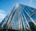 High-angle architectural view of a modern glass and steel curtain wall skyscraper featuring clean weatherproofing sealant joints.