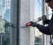 Professional application of a clean, non-staining MS Polymer expansion joint sealant on a modern commercial high-rise glass and stone curtain wall facade.